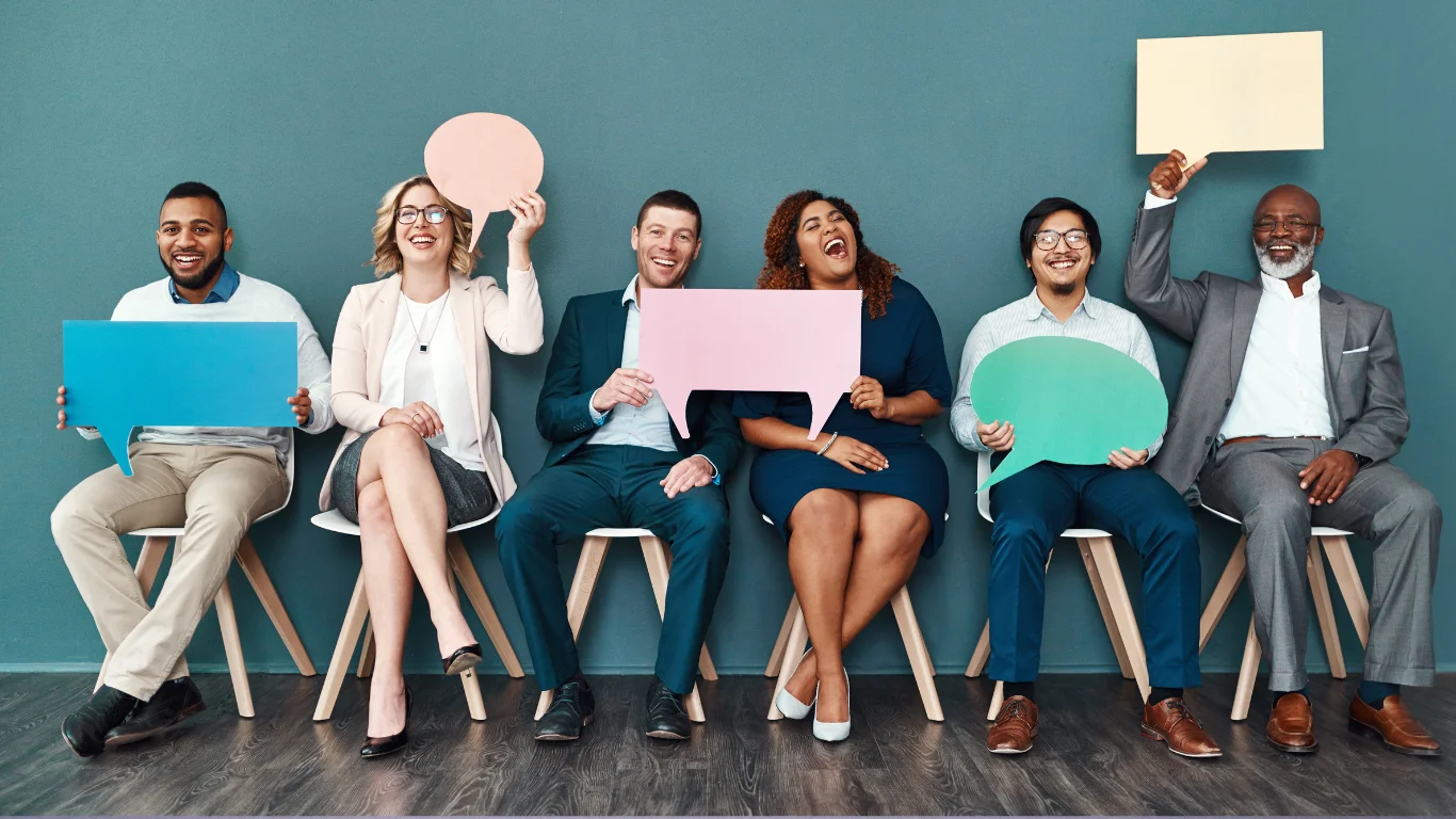Diverse group of professionals holding speech bubbles during recruitment session.
