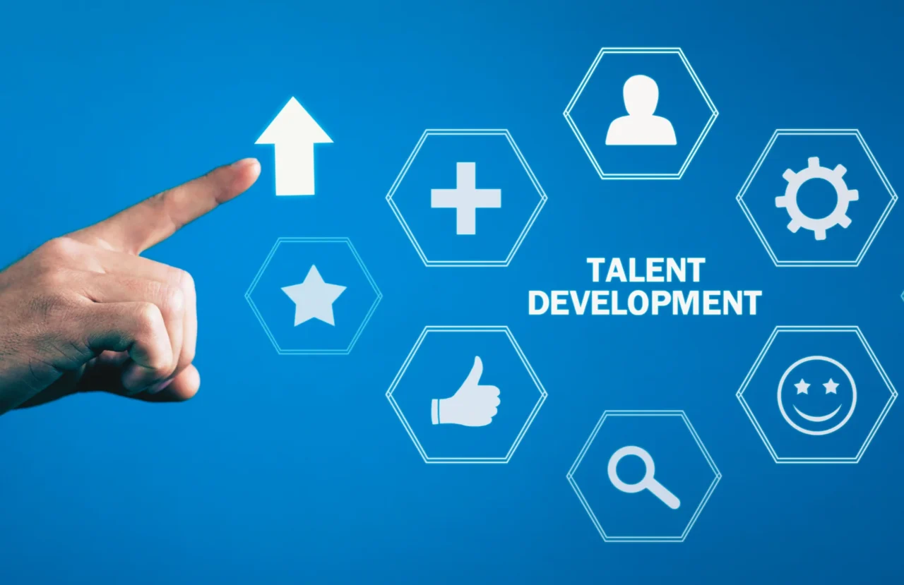 Hand pointing to an upward arrow beside talent development icons representing growth, skills and employee success.